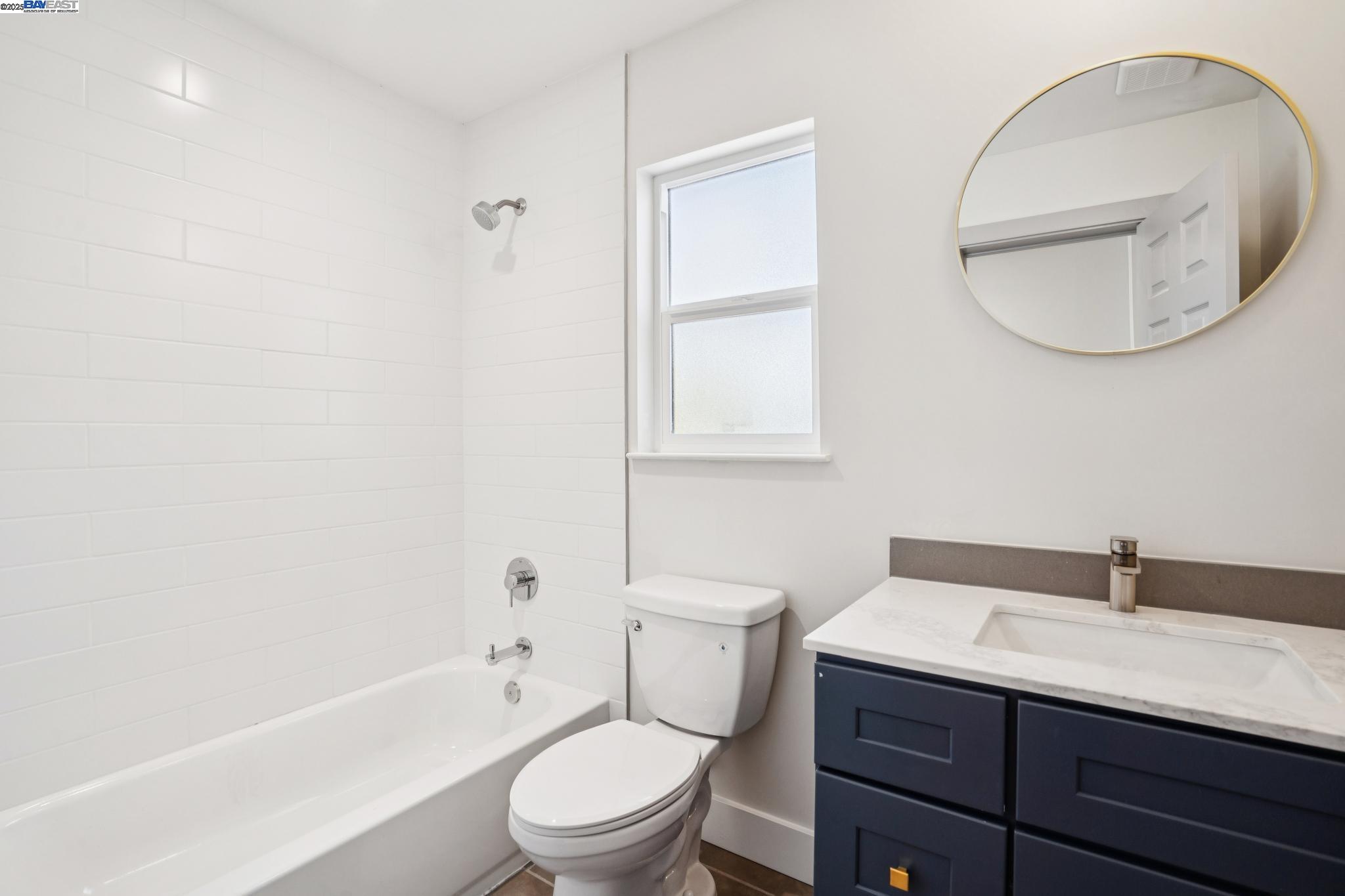 882 61st Street Oakland, CA 94608 - Photo 20 of 51 a bathroom with a toilet a sink a mirror and bathtub