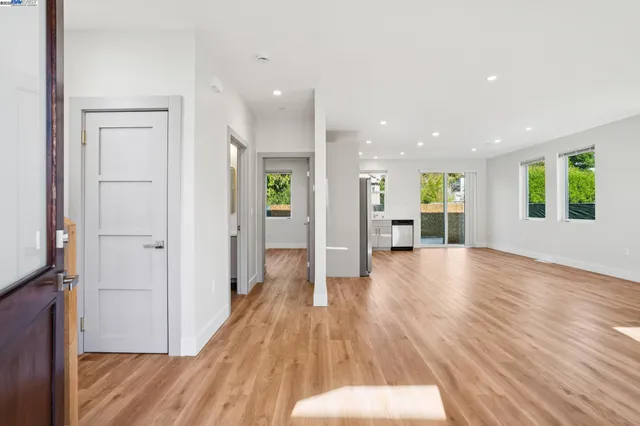 a view of a big room with wooden floor and windows