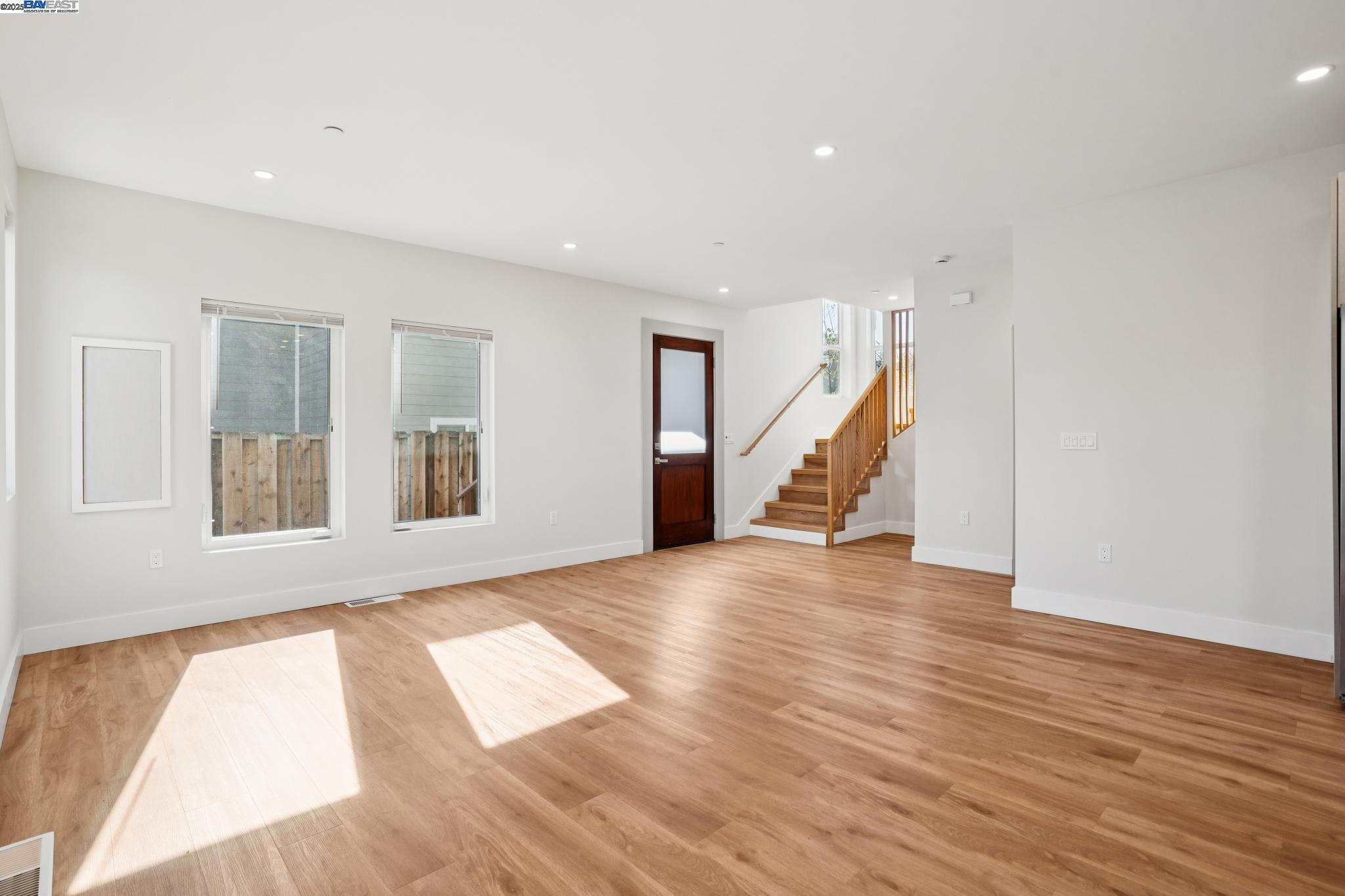 882 61st Street Oakland, CA 94608 - Photo 32 of 51 a view of an empty room with wooden floor and stairs