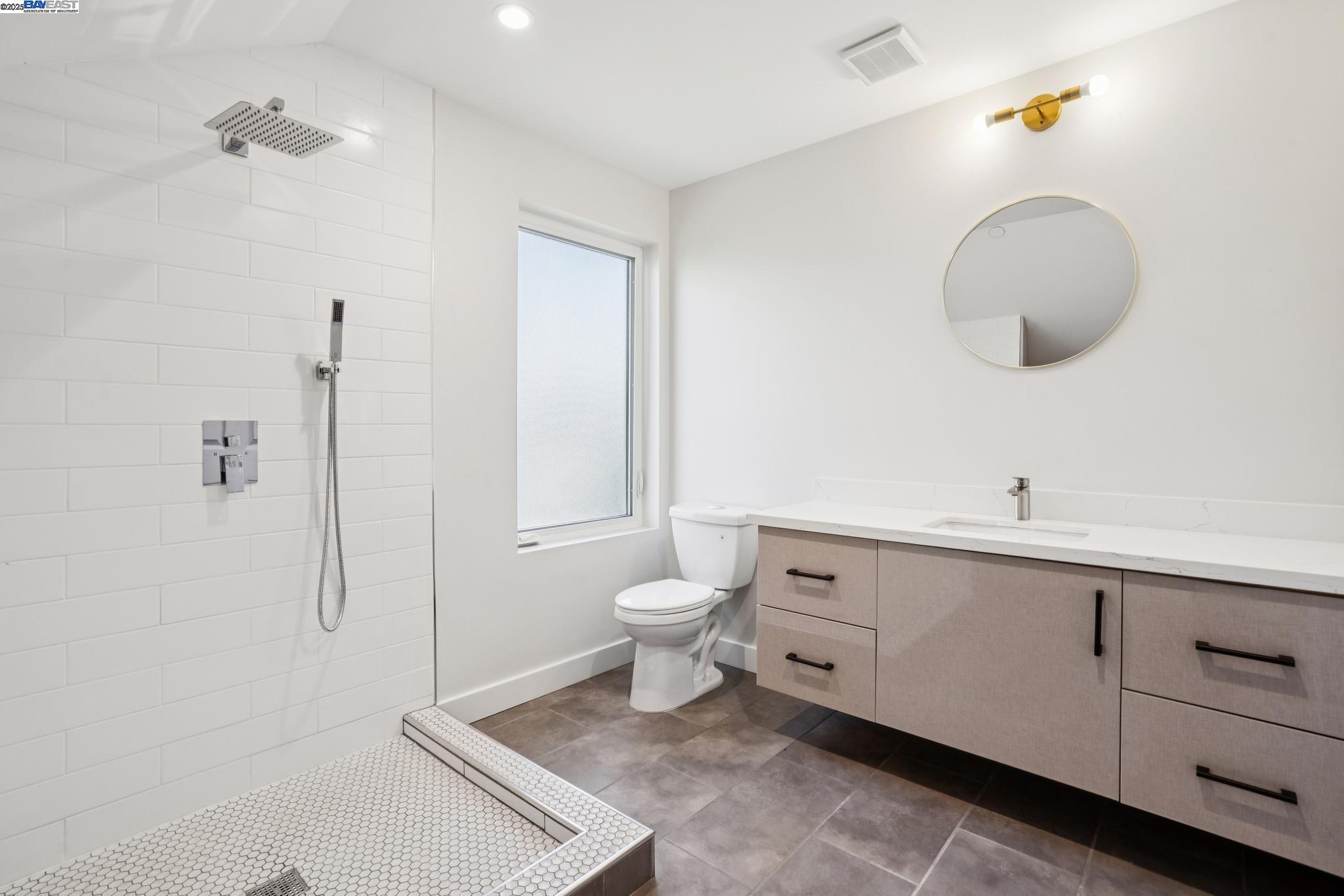 882 61st Street Oakland, CA 94608 - Photo 41 of 51 a spacious bathroom with a toilet a sink and mirror