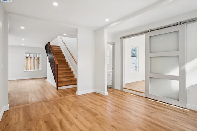 an empty room with wooden floor and stairs