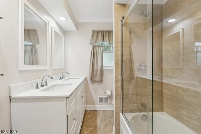 a bathroom with a double vanity sink a mirror and a shower