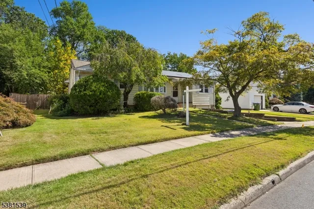 a view of a house with backyard and tree