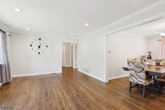 an empty room with wooden floor and a chandelier
