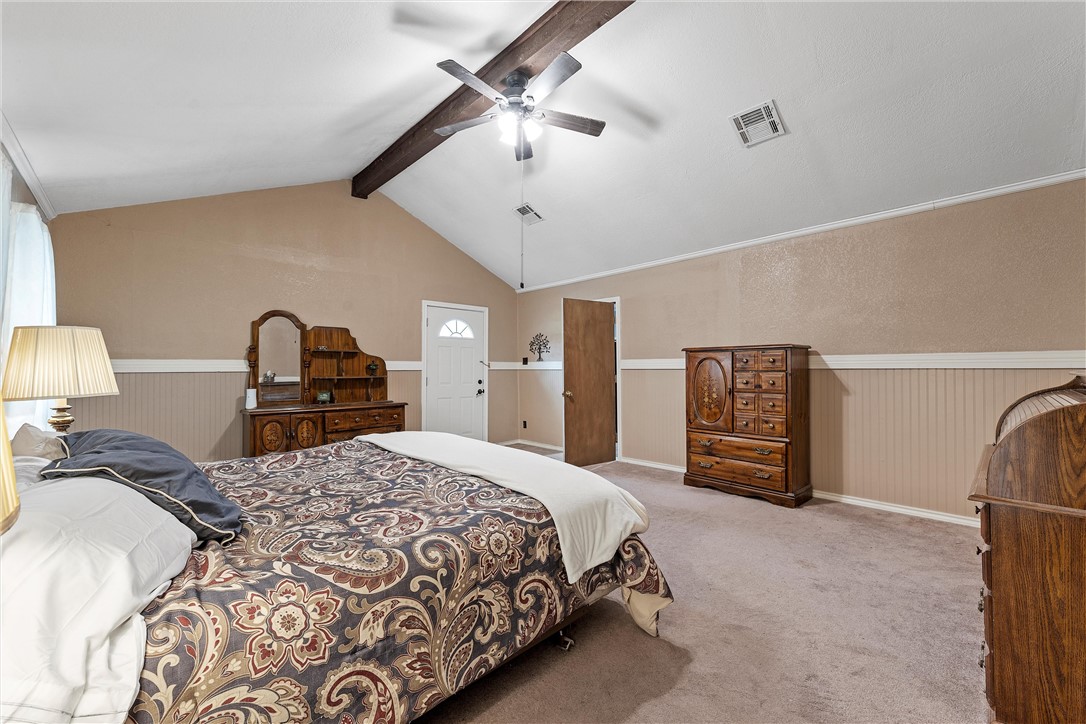 472 Coxs Oak Valley Road Waco, TX 76705 - Photo 21 of 47 a bedroom with a large bed and a chandelier