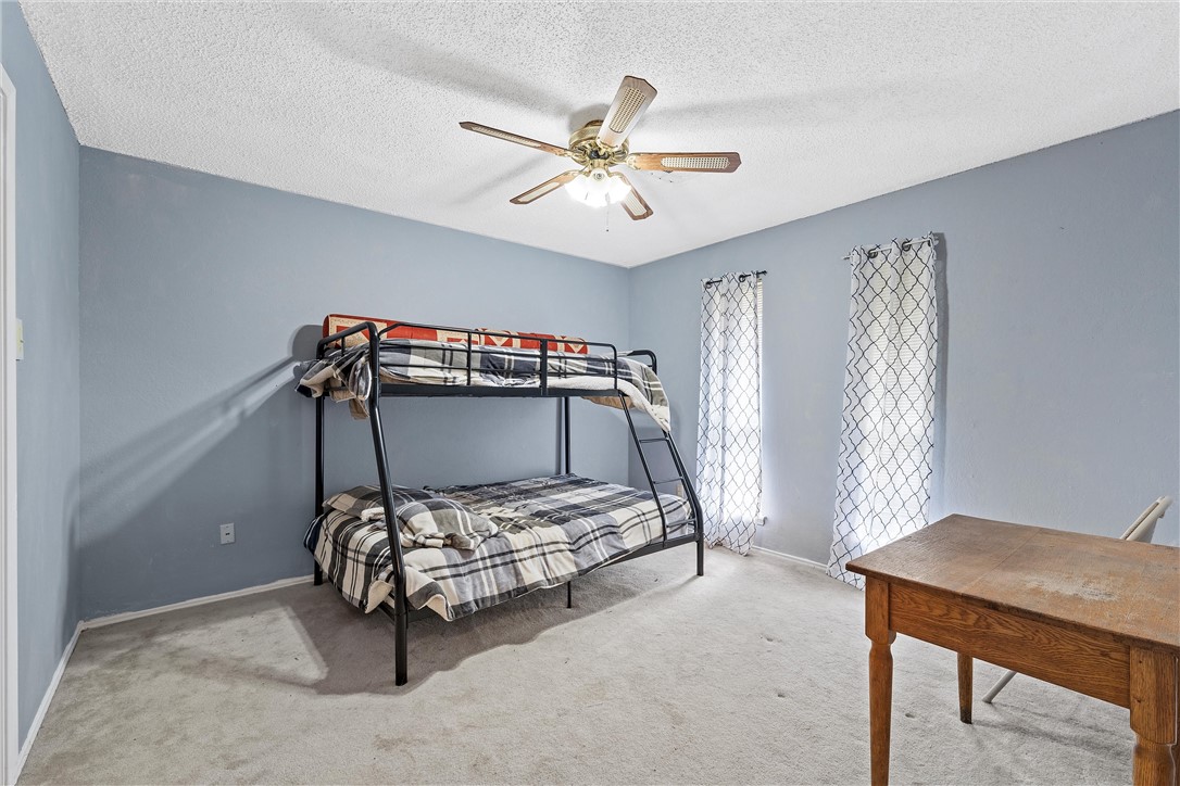 472 Coxs Oak Valley Road Waco, TX 76705 - Photo 9 of 47 a bedroom with a bed and a chandelier