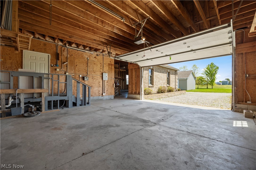 51488 Peck Wadsworth Road Wellington, OH 44090 - Photo 49 of 50 Spacious garage featuring a concrete floor, exposed wood beam ceiling, and an open overhead garage door