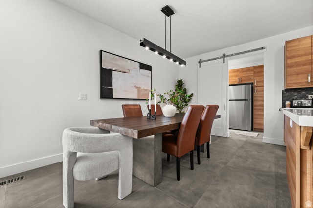 507 West Windmill Gate Cove Draper, UT 84020 - Photo 17 of 46 Dining room featuring a barn door and concrete flooring
