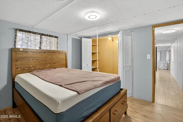 a bedroom with a bed and wooden floor