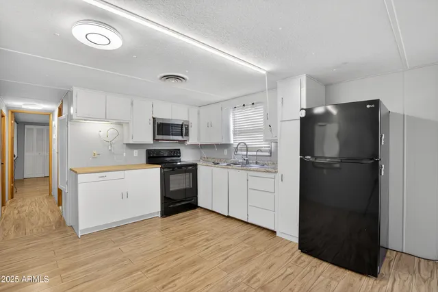 a kitchen with a refrigerator stove and white cabinets