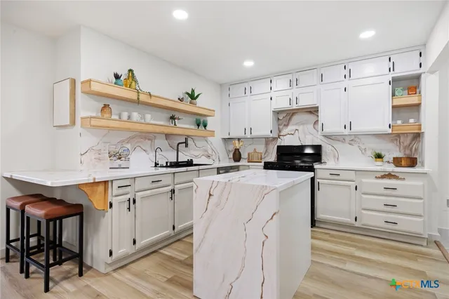 a kitchen with granite countertop white cabinets and white appliances