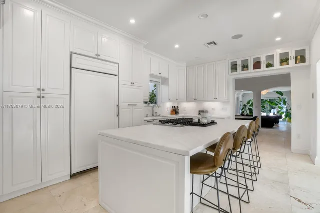 a kitchen with a table chairs refrigerator and cabinets