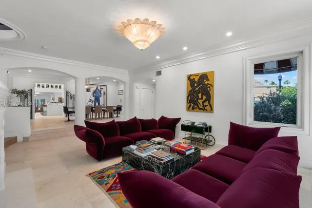 a living room with furniture a large window and a chandelier