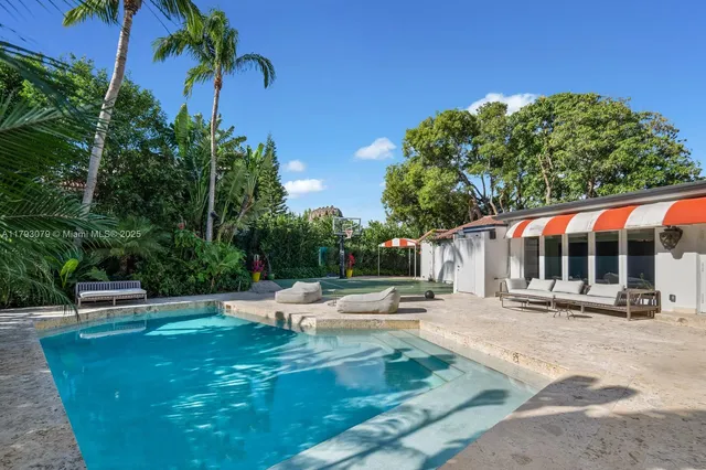 a view of a swimming pool with lawn chairs under an umbrella