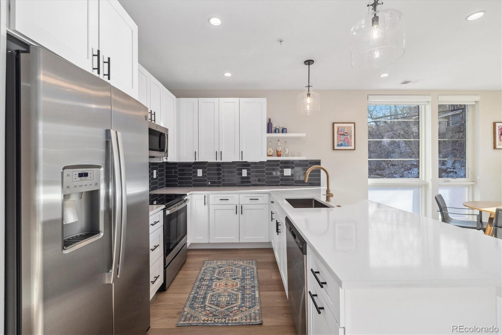 1401 Jackson Street, Unit 204 Golden, CO 80401 - Photo 8 of 26 a kitchen with stainless steel appliances granite countertop a sink a stove a refrigerator and island with wooden floor