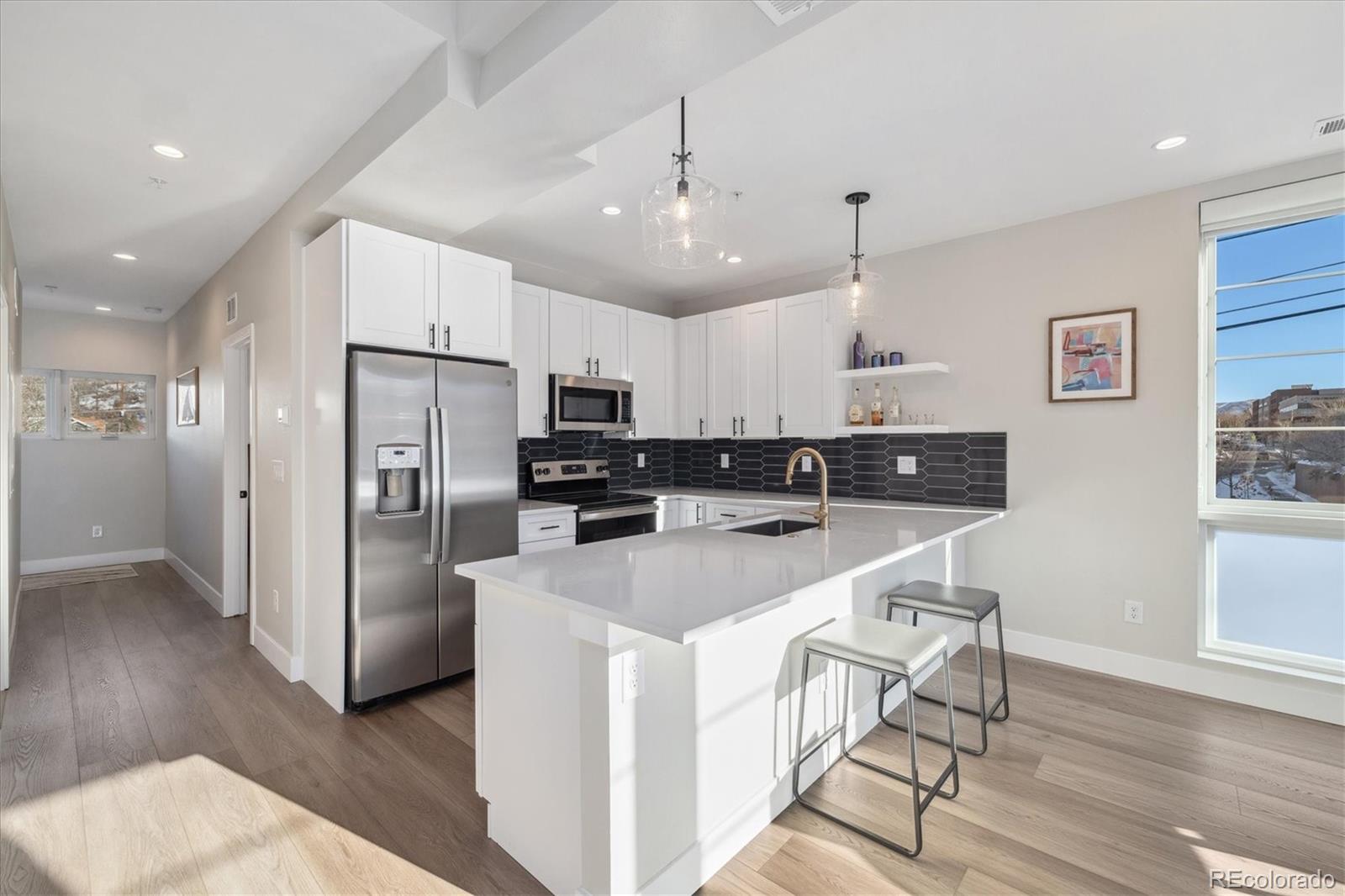 1401 Jackson Street, Unit 204 Golden, CO 80401 - Photo 9 of 26 a kitchen with kitchen island a refrigerator and a stove top oven