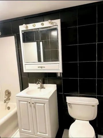 a bathroom with a toilet a sink and a mirror