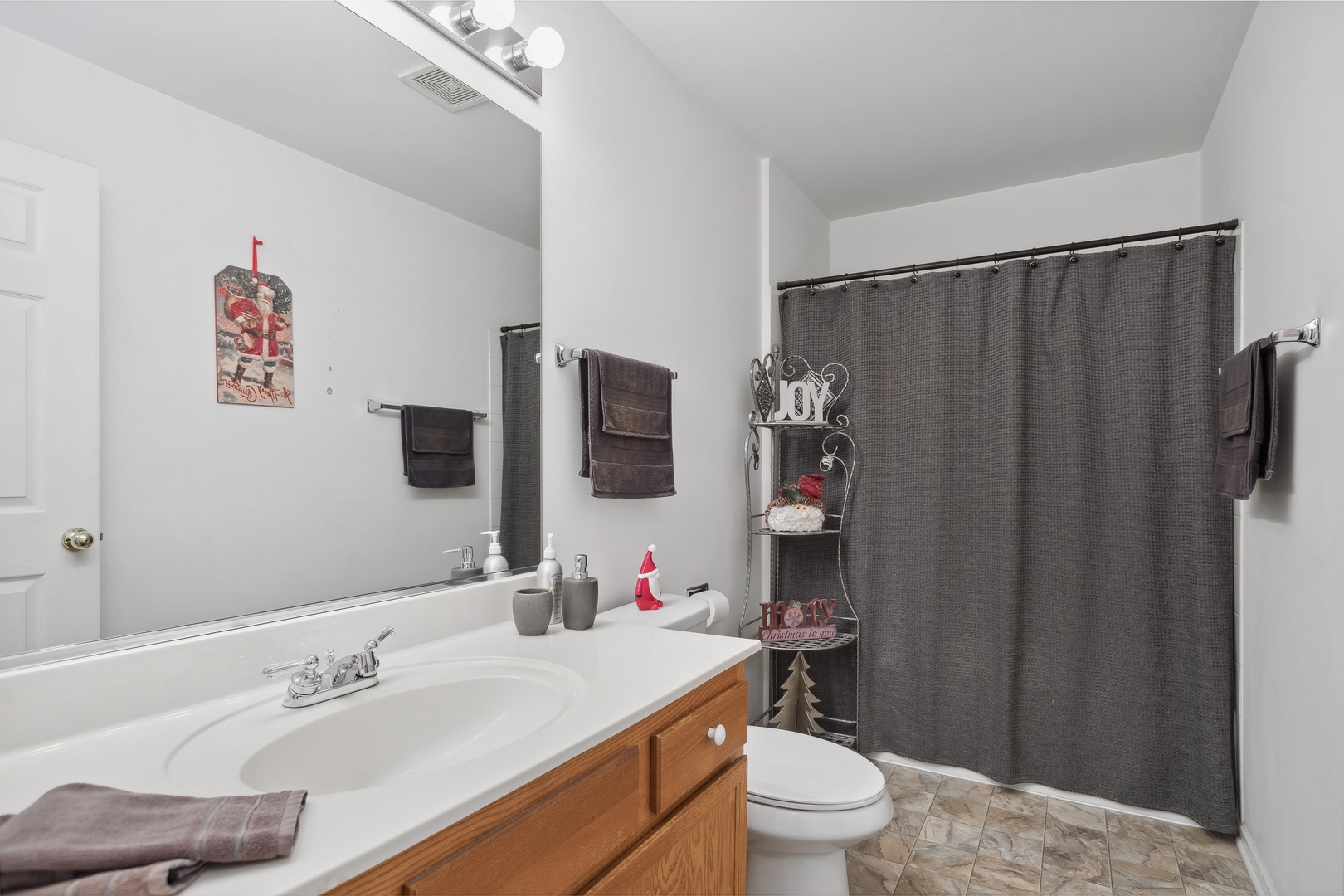 71 Larch Court, Unit B Schaumburg, IL 60193 - Photo 7 of 12 a bathroom with a sink a toilet and shower curtain