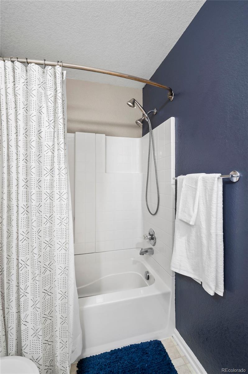 4570 South Swadley Court Morrison, CO 80465 - Photo 16 of 24 a bathroom with a bath tub and a shower curtain