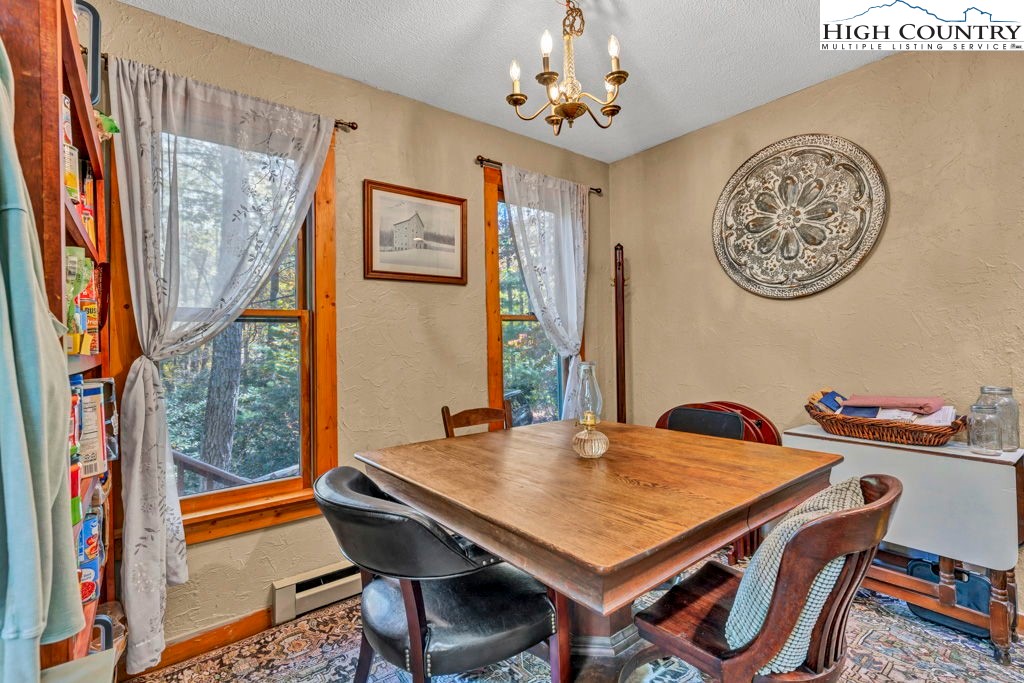 180 Wild Blackberry Hill Road Boone, NC 28607 - Photo 11 of 30 a view of a dining room with furniture window and wooden floor