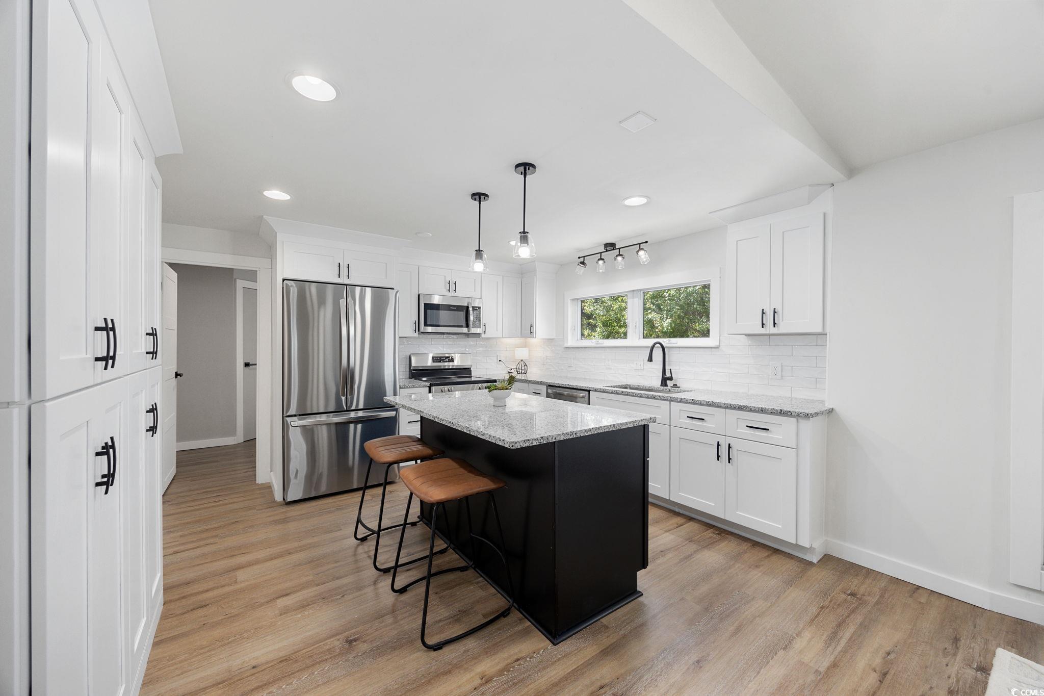 983 South Marlin Circle Murrells Inlet, SC 29576 - Photo 6 of 40 Kitchen featuring stainless steel appliances, decorative backsplash, a kitchen breakfast bar, light wood-style floors, and recessed lighting