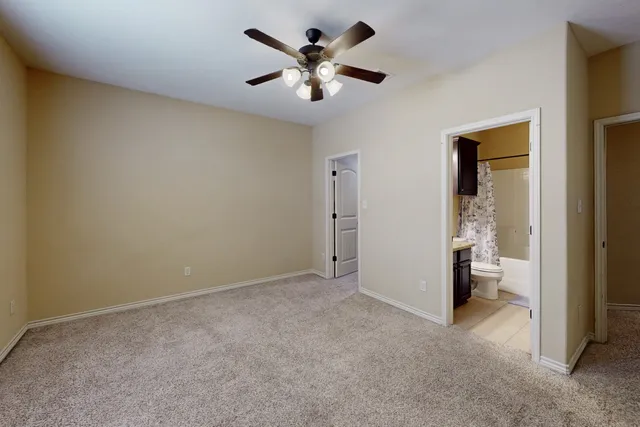 a view of an empty room and a ceiling fan