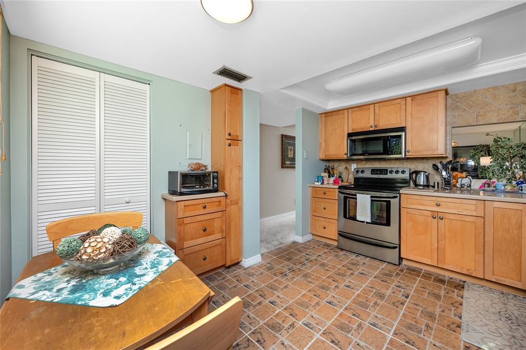 2737 Enterprise Road East, Unit 112 Clearwater, FL 33759 - Photo 13 of 43 a kitchen with granite countertop a stove top oven microwave and cabinets