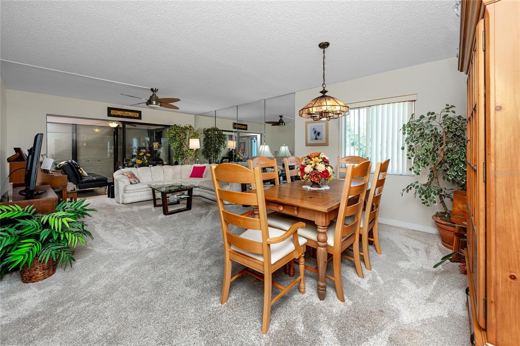 2737 Enterprise Road East, Unit 112 Clearwater, FL 33759 - Photo 18 of 43 a dining room filled with furniture and a chandelier