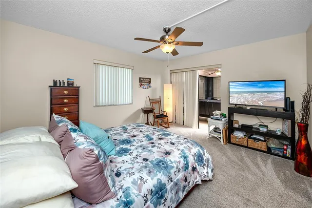 a spacious bedroom with a bed and a chandelier