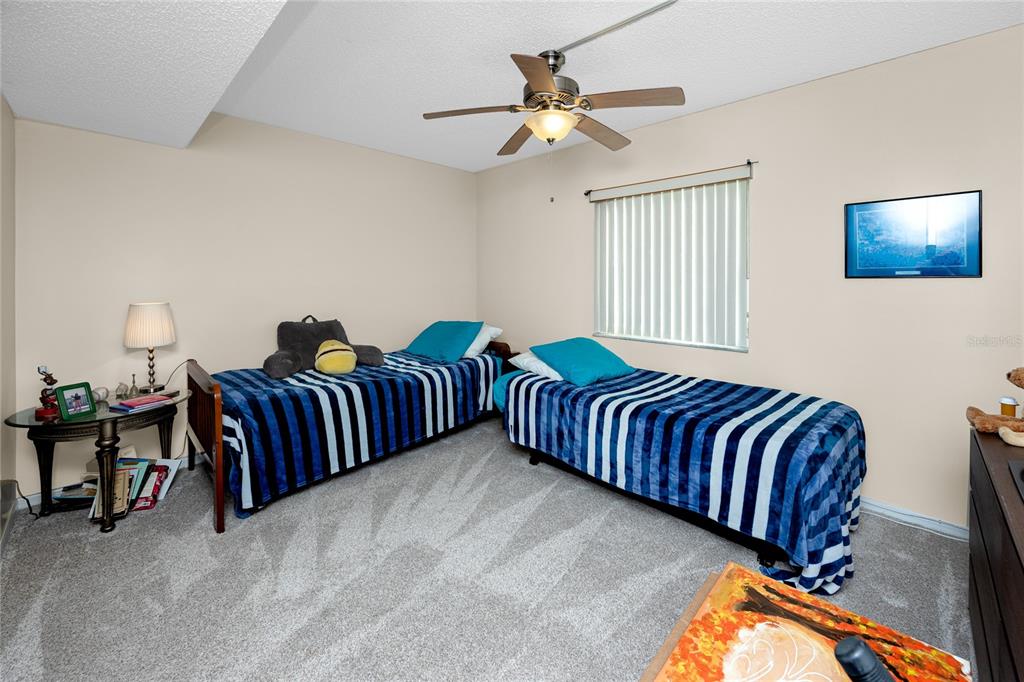 2737 Enterprise Road East, Unit 112 Clearwater, FL 33759 - Photo 28 of 43 a bedroom with bed and a chandelier