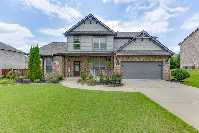 a front view of a house with yard and green space