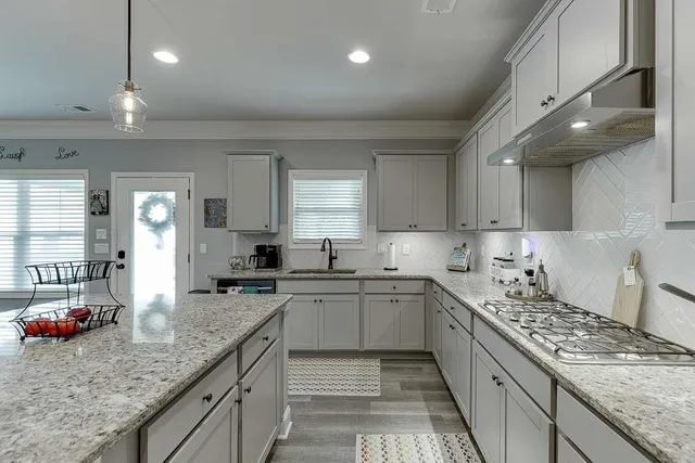 a kitchen with a stove sink and cabinets