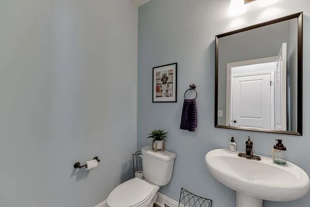 a bathroom with a toilet a sink and mirror