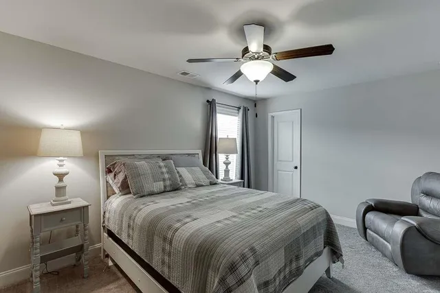 a bedroom with a large bed and a chandelier