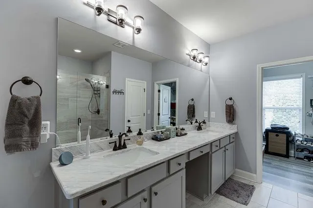 a bathroom with a double vanity sink mirror double and shower
