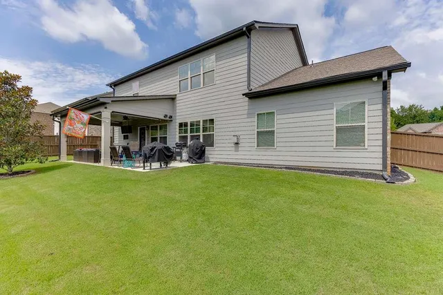 a view of a chair and table in backyard of the house