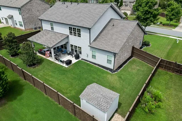 an aerial view of a house with a garden and lake view