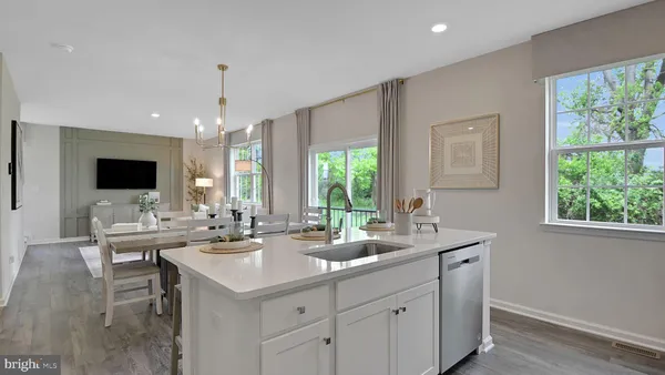 a kitchen with stainless steel appliances granite countertop white cabinets a stove a sink and dishwasher