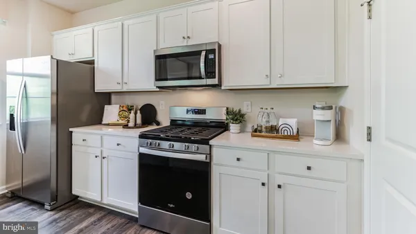a kitchen with stainless steel appliances kitchen island granite countertop a sink a stove a microwave cabinets and dining table