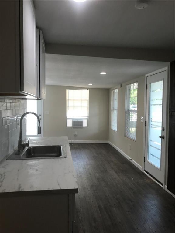 1119 Spur Street, Unit A Austin, TX 78721 - Photo 4 of 10 Modern kitchen with sleek counters opens to a spacious living area with resilient flooring.