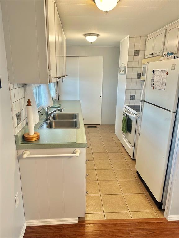 2000 East Bay Drive, Unit 102 Largo, FL 33771 - Photo 4 of 17 a kitchen with a sink a refrigerator and cabinets