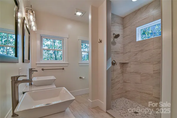 a bathroom with a sink a toilet and shower
