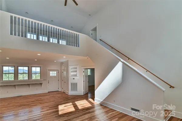 a kitchen with stainless steel appliances granite countertop a sink a stove a refrigerator and island with wooden floor