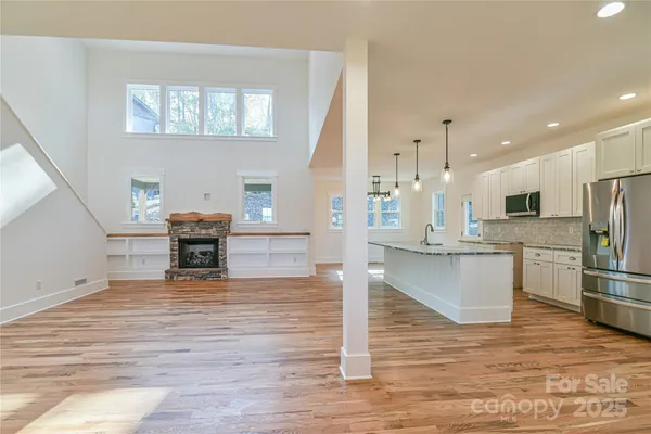 a large kitchen with stainless steel appliances granite countertop a stove a sink and a white cabinets