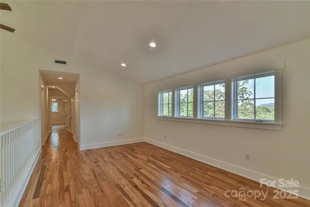 a view of a room with wooden floor and a window