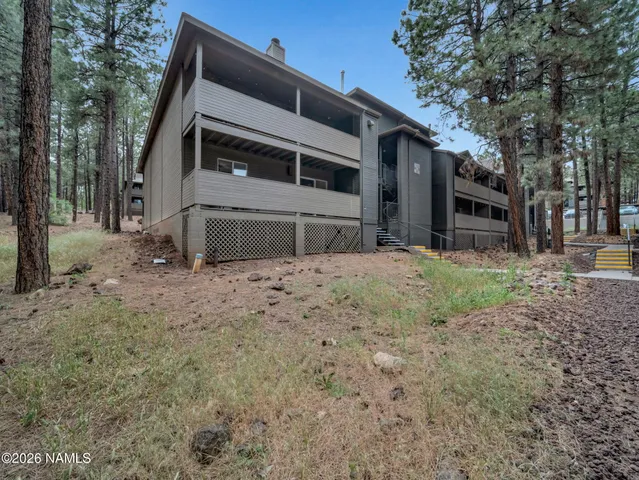 a view of a house with backyard and trees
