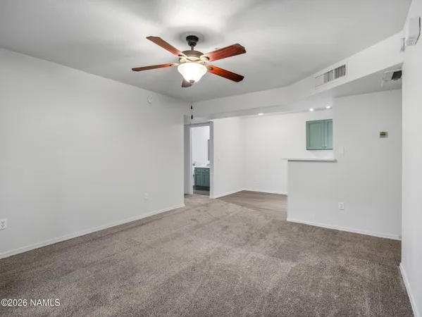 a view of an empty room with a ceiling fan