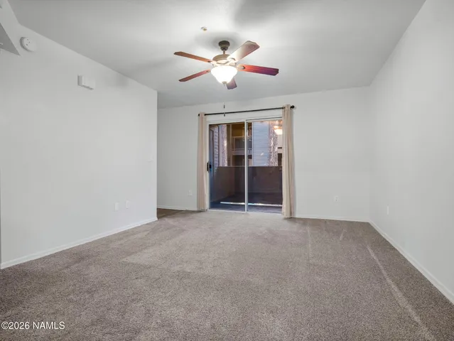 a view of an empty room with a ceiling fan