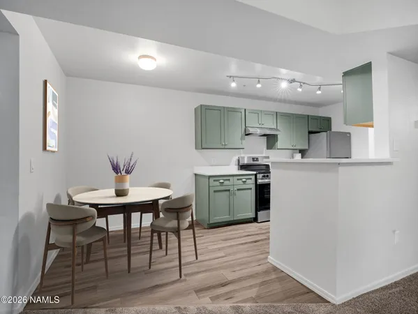 a kitchen with a table chairs sink and cabinets