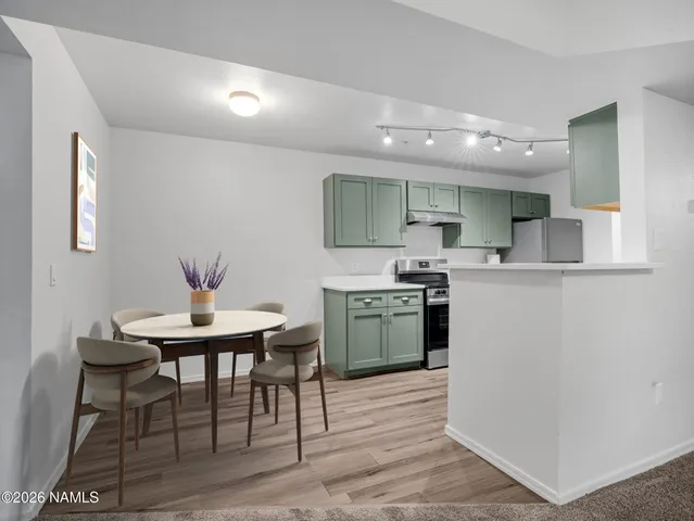 a kitchen with a table chairs sink and cabinets